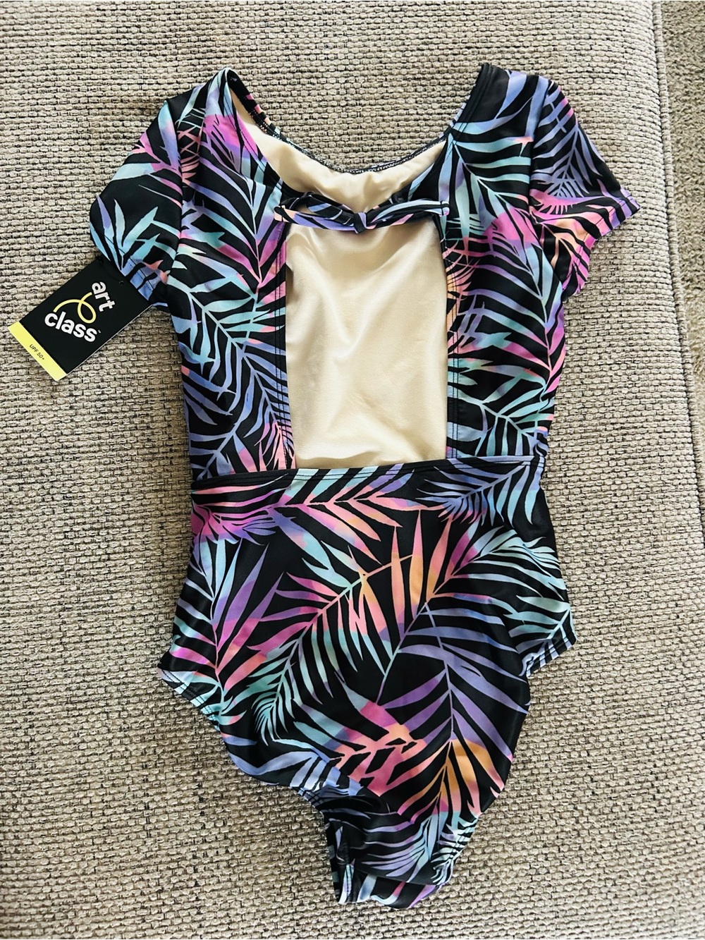 art class cream swimsuit with black trim and pastel accents